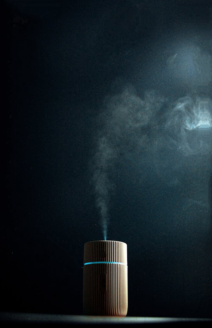 hero-img-02 Wooden fragrance diffuser emitting steam against a dark background, creating a soothing ambiance.